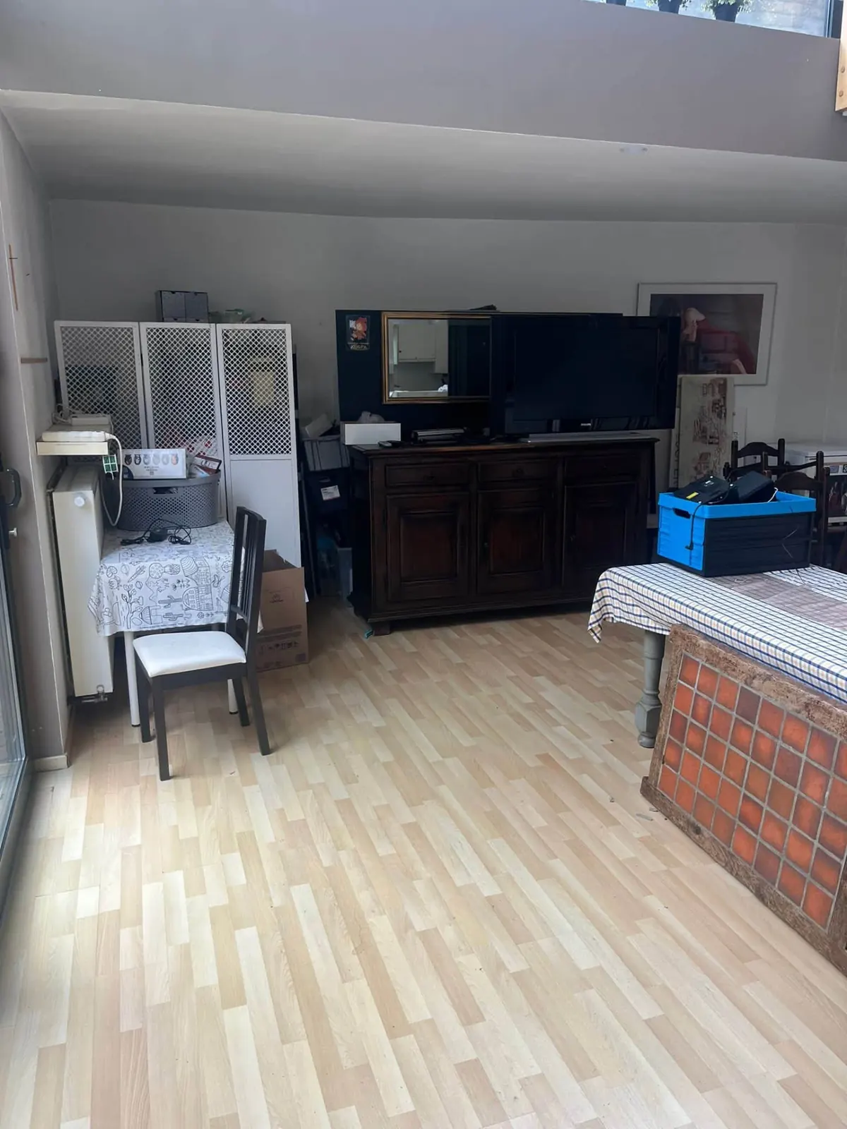 Inboedel verwijderen woning Brugge: leefruimte met kast, televisie en huisraad vóór de start van de opruiming
